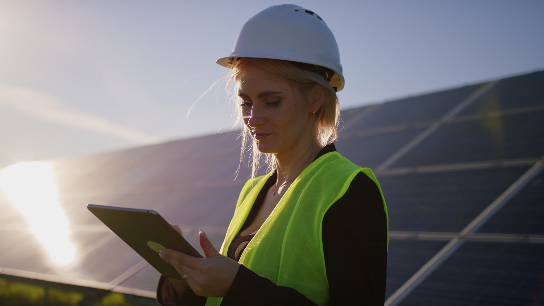 Ingenieurin mit Tablet vor Solaranlagen