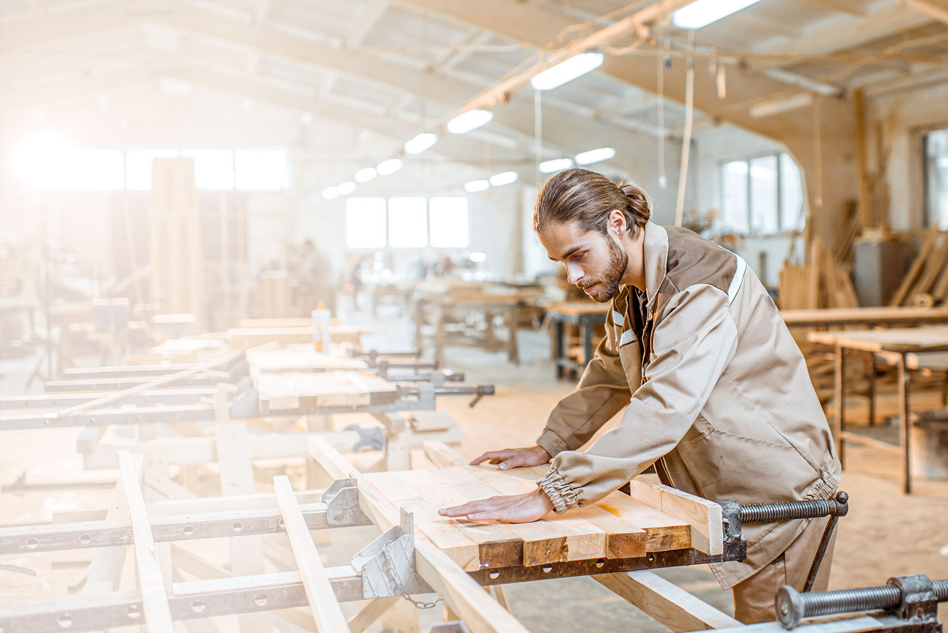 Junger Schreiner verarbeitet Holz in einer Werkstatt