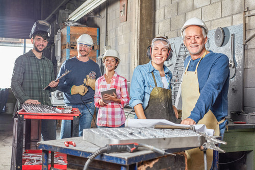 Handwerkerkollegium posiert in der Werkstatt